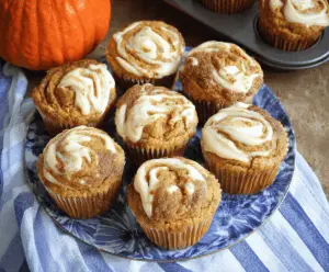 Delicious moist pumpkin cream cheese muffins topped with a cinnamon swirl and cream cheese filling, perfect for fall baking.