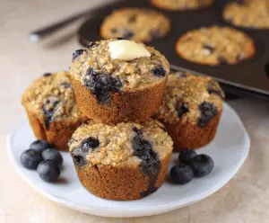 Delicious homemade oatmeal blueberry muffins made without flour, featuring golden tops and fresh blueberries in each muffin