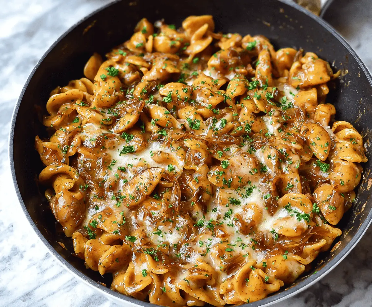 Creamy One Pot French Onion Pasta dish topped with melted cheese and caramelized onions, served in a bowl for a comforting and easy dinner recipe.