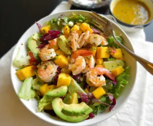 Fresh shrimp and ripe mango salad served with greens for a delicious and healthy meal.