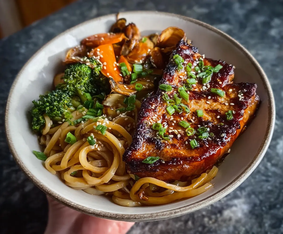 Delicious Veggie Udon noodles topped with colorful vegetables and served with succulent Sticky Glazed Pork Chops.