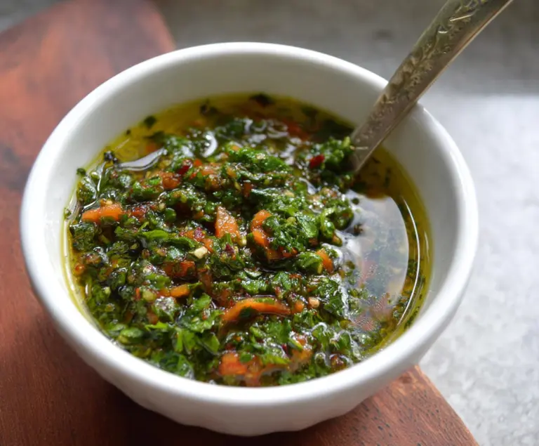 Fresh carrot top chimichurri sauce served in a small bowl, highlighting vibrant green herbs and garlic.