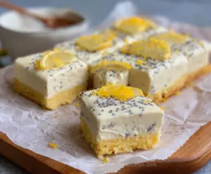 Delicious Keto Lemon Poppy Seed Cottage Cheese Bars on a white plate with fresh lemon slices.